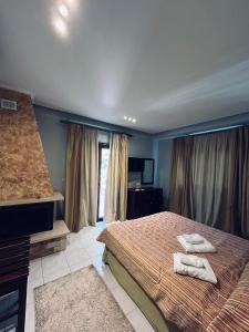 a bedroom with a bed with two towels on it at Hotel Athina in Kato Loutraki