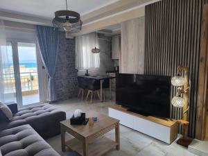 a living room with a large flat screen tv at Aphrodite Sea View Apartment in Perea