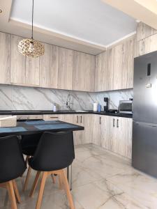 a kitchen with wooden cabinets and a table and chairs at Aphrodite Sea View Apartment in Perea