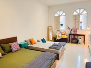 two beds in a room with windows at Georgetown Kyash House 23 in George Town