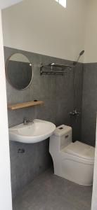 a bathroom with a sink and a toilet and a mirror at Xóm Giữa homestay in Ha Tien