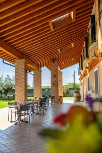 patio ze stołami i krzesłami pod drewnianym sufitem w obiekcie Agriturismo Ca' Del Gal w mieście Valeggio sul Mincio