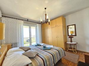 une chambre avec un grand lit et une fenêtre dans l'établissement LEO ROOM 2 NV - Room for 2-3 persons with bathroom, balcony (no kitchen), à Novi Vinodolski