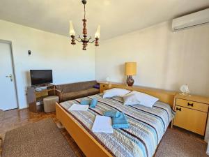 une chambre avec un grand lit et un canapé dans l'établissement LEO ROOM 2 NV - Room for 2-3 persons with bathroom, balcony (no kitchen), à Novi Vinodolski