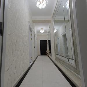 un corridoio con pavimento piastrellato bianco in un edificio di Апартамент с 3 комнатами a Muruntau