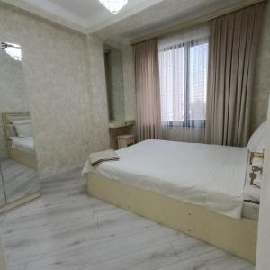 una camera da letto con un letto e una grande finestra di Апартамент с 3 комнатами a Muruntau