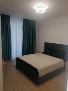 Schlafzimmer mit einem Bett und blauen Vorhängen in der Unterkunft MARIA Sea View Lake ON in Mamaia