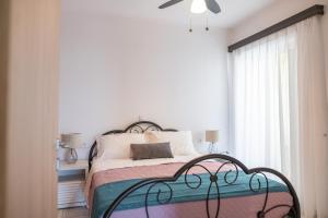 a bedroom with a bed and a ceiling fan at Island Memories Apartment in Ampavris