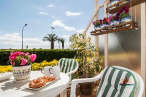 a table with a plate of croissants and two chairs at Seafront L'Estartit Apartments in L'Estartit