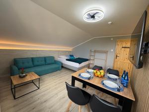 a living room with a blue couch and a table at Przystań Pod Wieżą in Władysławowo