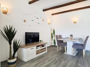 ein Wohnzimmer mit Fernseher und Tisch mit Stühlen in der Unterkunft APT QUINTA PARAÍSO - Swimming Pool & Garden in Carvoeiro