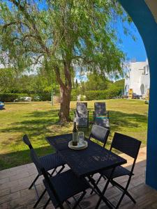 einen Tisch und Stühle auf einer Terrasse mit einem Baum in der Unterkunft APT QUINTA PARAÍSO - Swimming Pool & Garden in Carvoeiro