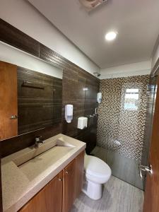 a bathroom with a toilet and a sink and a shower at Hotel Bahia Guatape in Guatapé