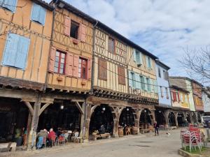an old building with people sitting outside of it at L'escapade colorée anciennement La Vieille Forge in Rieux-Minervois