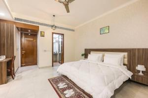 a bedroom with a large white bed and a desk at Green stays brighter days in Gurgaon