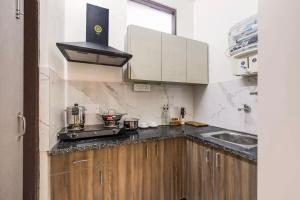 a small kitchen with a stove and a sink at Green stays brighter days in Gurgaon