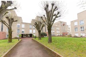 a group of trees in front of a building at Chambre 1 Cosy & Warm in Evry-Courcouronnes