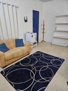 a living room with a couch and a rug at Shanti Om Refúgio Pousada e Yoga in Cascavel