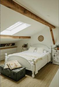 a bedroom with a white bed and a skylight at LaChillmaisonnette in Labenne