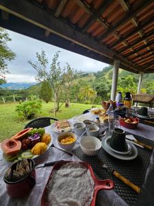 una mesa con comida encima de una mesa en Cantinho Paraíso da Mantiqueira SFX pet friendly, en São Francisco Xavier