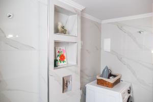 a bathroom with white marble walls and a white niche at Island Memories Apartment in Ampavris +43 photos