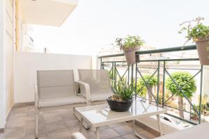 a balcony with two chairs and a table and plants at Island Memories Apartment in Ampavris