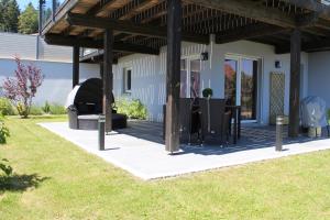 a patio with a grill and a table and chairs at Gite chez Isabelle in Villers-le-Lac