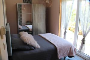 a bedroom with a mirror and a bed and a window at Gite chez Isabelle in Villers-le-Lac