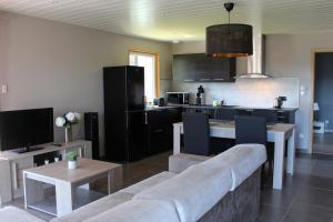 a living room with a couch and a kitchen at Gite chez Isabelle in Villers-le-Lac