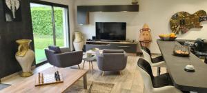 ein Wohnzimmer mit einem Tisch und einigen Stühlen in der Unterkunft Villa Neves in Saint-Cyr-sur-Loire