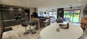 eine Küche und ein Wohnzimmer mit einem weißen Tisch und Stühlen in der Unterkunft Villa Neves in Saint-Cyr-sur-Loire