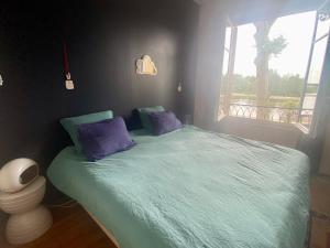 オルレアンにあるBalcon vue Loire parking à 50mのベッドルーム1室(紫色の枕が付くベッド1台、窓付)