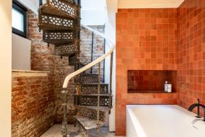 a bathroom with a bath tub next to a brick wall at Jardin du Béguinage - Peaceful Luxury Home in Brussels in Brussels +16 photos