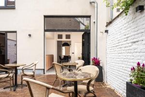 a patio with tables and chairs and a brick wall at Jardin du Béguinage - Peaceful Luxury Home in Brussels in Brussels
