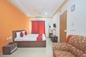 a hotel room with a bed and a couch at Hotel O Garden Green in Bengaluru +11 photos