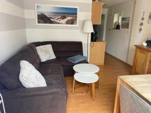 una sala de estar con un sofá y una mesa en Haus Carstensen-Bungalow 3, en Wyk auf Föhr