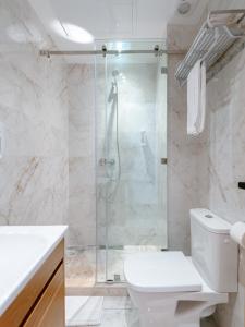 a bathroom with a toilet and a glass shower at Spinoza House Appart Hôtel in Casablanca