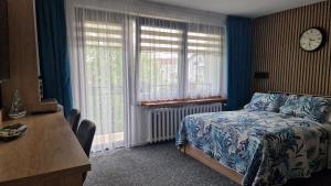 a bedroom with a bed and a clock on the wall at BALTIC SAND - Ośrodek Wypoczynkowy Władysławowo - Cetniewo in Władysławowo