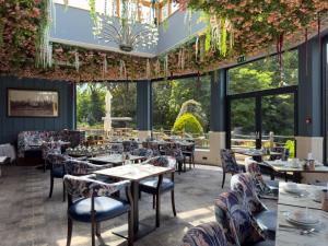 a restaurant with tables and chairs and large windows at The Mount Country Manor Hotel & Golf Wolverhampton in Wolverhampton