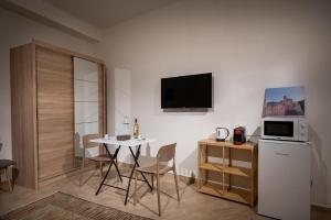 a kitchen and dining room with a table and a microwave at Sofia Rooms in Castellammare del Golfo