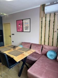 a living room with a purple couch and a wooden table at VeliApartmets in Velingrad