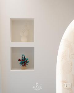 a shelf in a white room with a figurine on it at MARE Tropea Boutique Rooms in Tropea +68 photos