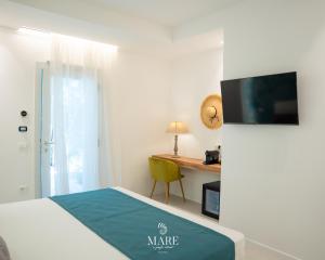 a bedroom with a bed and a desk with a television at MARE Tropea Boutique Rooms in Tropea