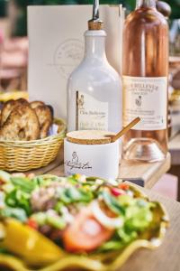 a table with a plate of food and a bottle of alcohol at La Ferme D'Augustin in Saint-Tropez