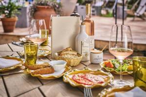 a table topped with plates of food and wine glasses at La Ferme D'Augustin in Saint-Tropez