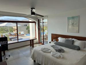 - une chambre avec un lit et une vue sur une terrasse dans l'établissement El Tular 002 2 bedroom villa 7 mins walk from La Ropa beach, à Zihuatanejo