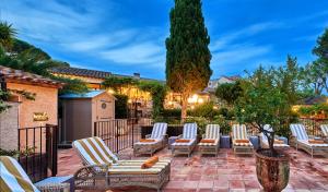 a group of lounge chairs on a patio at La Ferme D'Augustin in Saint-Tropez
