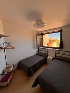 una camera da letto con due letti e una grande finestra di Apartamento Pasarelas Ventanal ad Alquézar