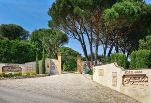a driveway leading to the entrance to a park with trees at La Ferme D'Augustin in Saint-Tropez +37 photos