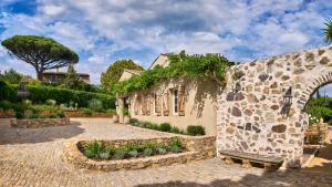 a stone building with a bench in front of it at La Ferme D'Augustin in Saint-Tropez